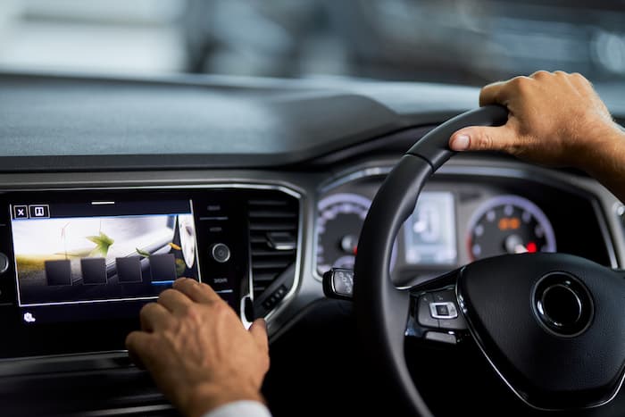 Mand der sidder i en bil, som trykker på en digital skærm